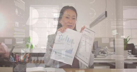 Korean businesswoman presenting analytics report with charts and graphs in modern office