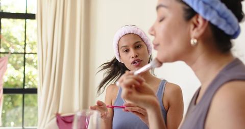 Friends applying makeup together at home vanity morning skincare and beauty routine
