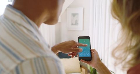 Couple Utilizing Home Automation in Modern Living Space