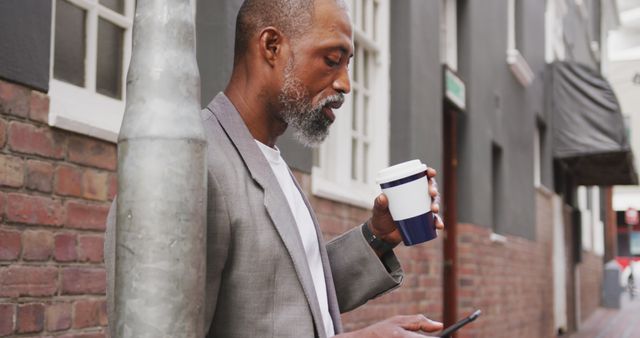 Businessman Enjoying Coffee While Checking Smartphone on City Street - Download Free Stock Images Pikwizard.com