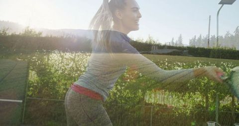 Dynamic Female Tennis Player on Grass Court with Sunlight Glare