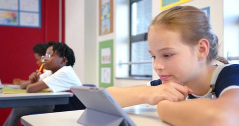 Students Engaging with Tablet in Diverse Classroom Setting