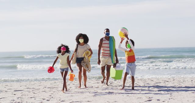 Family with children walking on beach, wearing masks for safety. Capturing moments of summer fun and relaxation by the ocean, while emphasizing safety measures. Useful for themes related to family vacations, outdoor activities, and health during pandemic times.