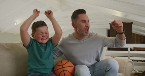 Father and Son Celebrating a Basketball Game Victory at Home
