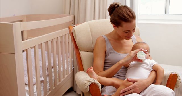 Mother Feeding Baby with Bottle in Nursery - Download Free Stock Images Pikwizard.com