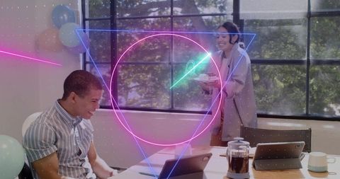 Coworker smiling while celebrating with cupcakes and laptops in modern office neon overlay