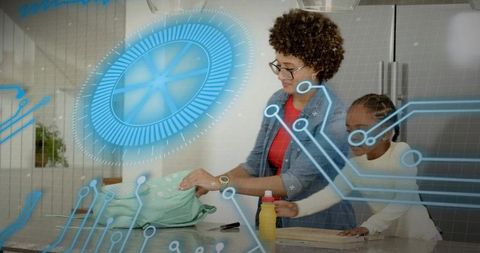 African american mother and daughter folding laundry with augmented reality interface
