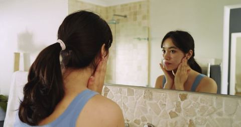 Asian Woman Skincare Routine at Bathroom Mirror