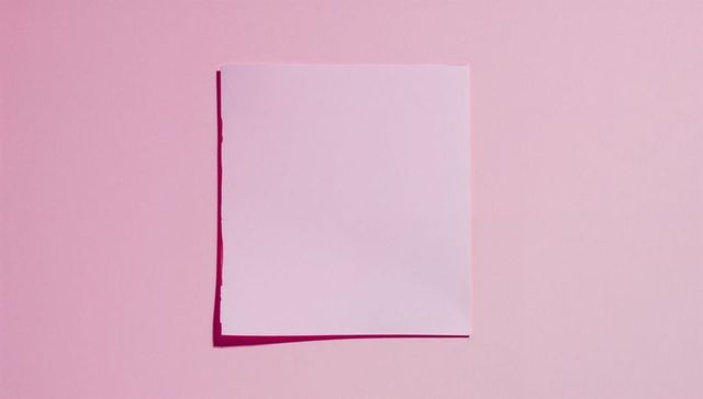 Minimalist white paper on pastel pink background