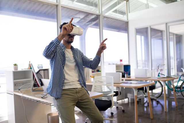 Male executive using virtual reality headset in office