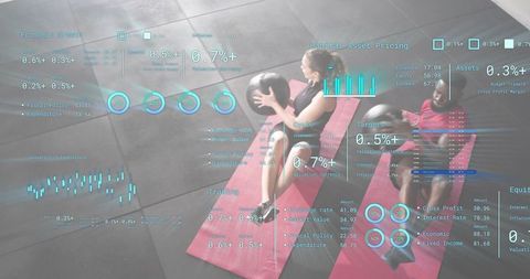 Duo performing medicine ball core workout on red mats with hologram fitness charts