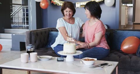 Senior Friends Celebrating Birthday with Cake and Candles Indoors