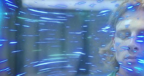 Blond man meditating with neon blue light streaks in holographic dreamy studio portrait