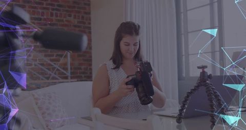 Female vlogger using camera and laptop with digital data networks