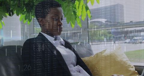 Contemplative businesswoman on leather sofa with financial data overlay and urban skyline