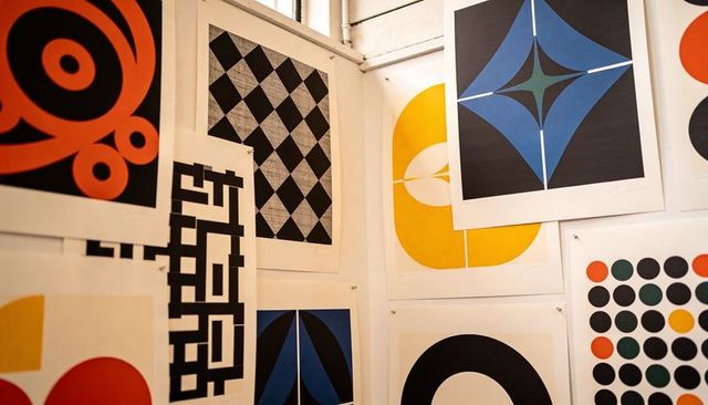 Vibrant Geometric Screen Prints Pinned Corner Wall Creating Bold Abstract Gallery Display