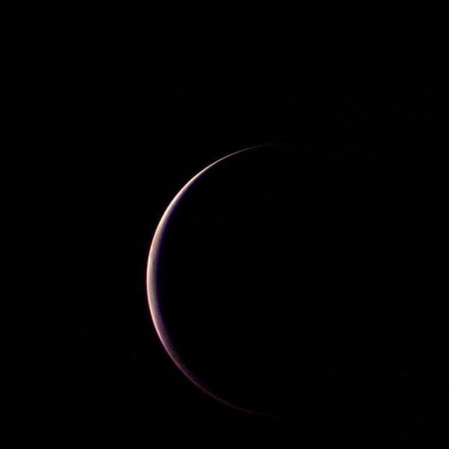 Crescent view of Triton, Neptune's largest moon, taken by NASA's Voyager 2 during its flyby on August 25, 1989. The image showcases the moon partially illuminated by the Sun, creating a stunning crescent effect. Ideal for use in educational materials, articles about space exploration, or presentations on the Voyager missions and astronomical phenomena.
