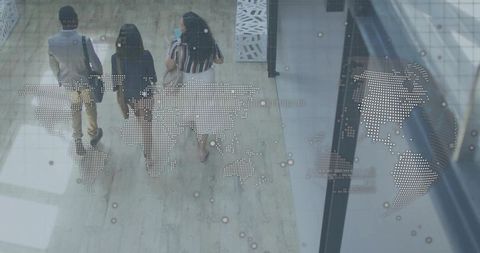 Multicultural team walking through atrium with world map overlay and digital network