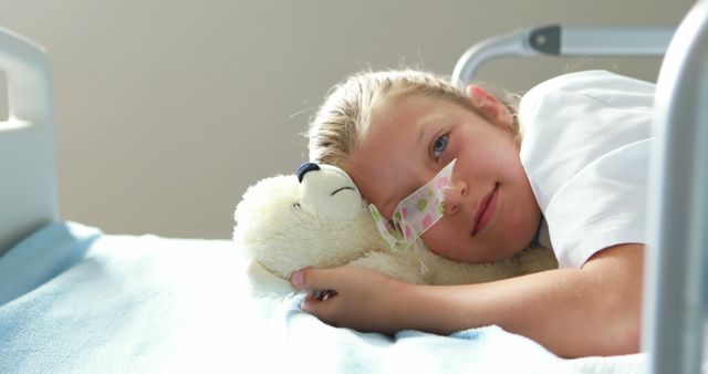 Girl in Hospital Bed Hugging Teddy Bear Smiling Gently - Download Free Stock Images Pikwizard.com