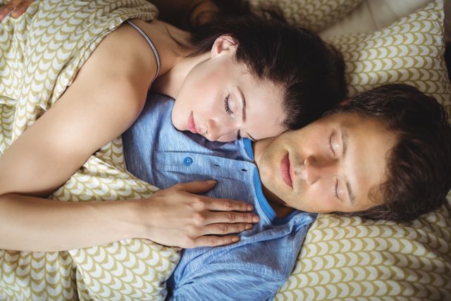 Romantic couple sleeping peacefully in bed, showcasing love and intimacy. Ideal for use in articles about relationships, sleep health, and lifestyle. Perfect for advertisements promoting bedding, sleep aids, or romantic getaways.