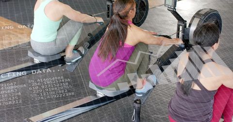 Diverse Women Rowing with Data Interface Overlay in Modern Gym