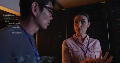 It engineers discussing server diagnostics in datacenter with code overlay and led racks