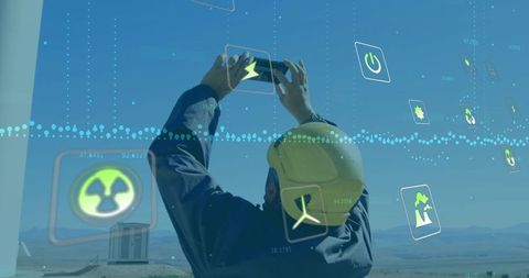 Worker Taking Photographs Near Wind Turbine with Digital Eco Graphics Overlay