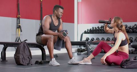Active Duo Hydrating and Resting at Gym for Recovery