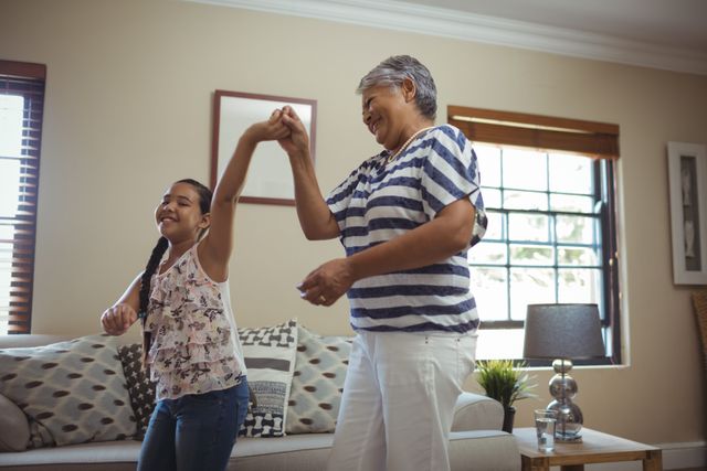 Grandmother and granddaughter having fun in living room at home