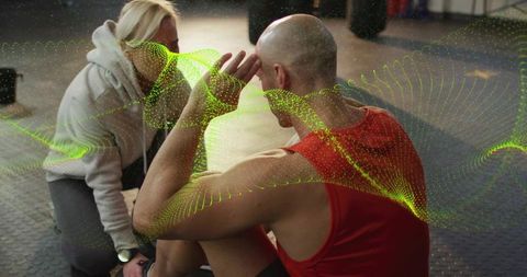 Personal trainer coaching bald athlete doing crunches with wearable tracker and waveform