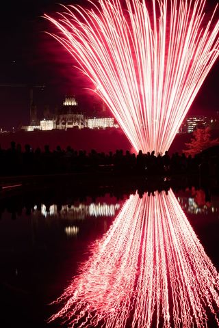 Spectacular Fireworks Display Reflecting on Water at Night