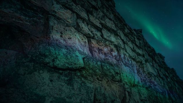 Aurora-Lit Rugged Stone Wall Revealing Textured Crags, Lichen and Night Sky Glow