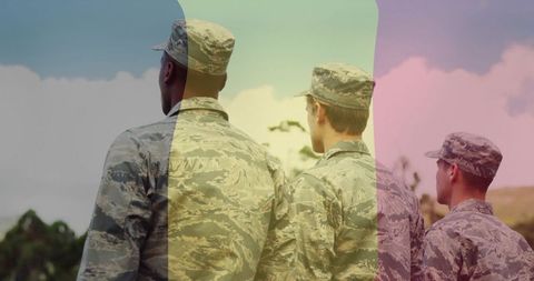 Three troops standing at horizon wearing camo uniforms and patrol caps with color overlays