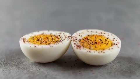 Camera focus shifting on halved hard-boiled eggs highlighting spiced yolks on gray slate