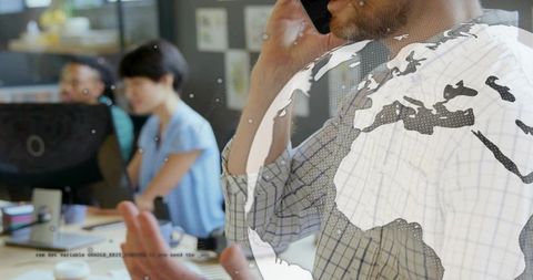 Mature man talking on smartphone, gesturing while collaborating with team, globe overlay