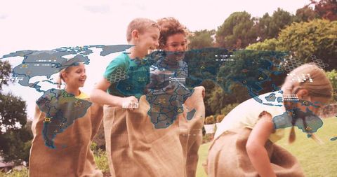 Children hopping in burlap sacks with holographic world map overlay in park