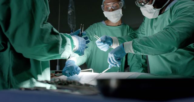 Focused diverse surgeons wearing face masks during surgery in operating room - Download Free Stock Photos Pikwizard.com
