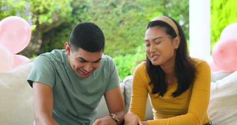 Playful Young Couple Relaxing with Snacks Outdoors
