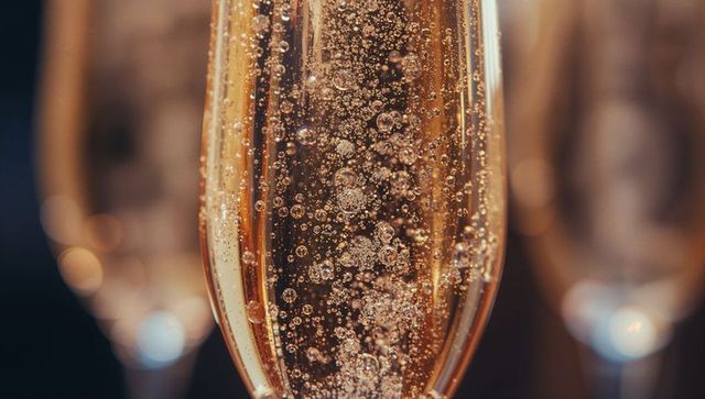 Exquisite Champagne Flute with Bubbly Golden Drink in Warm Ambiance