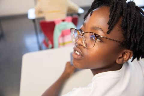 Curious African American Schoolboy Wearing Eyeglasses in Classroom