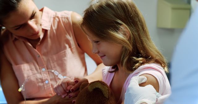 Smiling Girl Holding Teddy Bear Getting Vaccine in Clinic - Download Free Stock Images Pikwizard.com