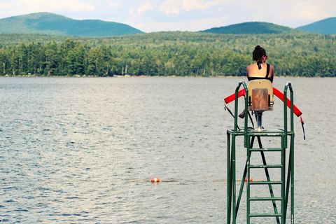 Lifeguard surveying tranquil lake landscape on summer day