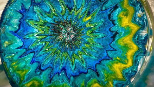 Vibrant abstract resin art with radiant bursts in metallic tray