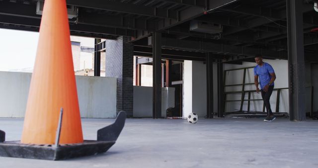 Man Practicing Soccer Skills Indoors with Orange Cone - Download Free Stock Images Pikwizard.com