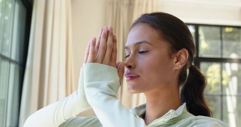 African american woman practicing mindfulness meditation at home near sunlit window