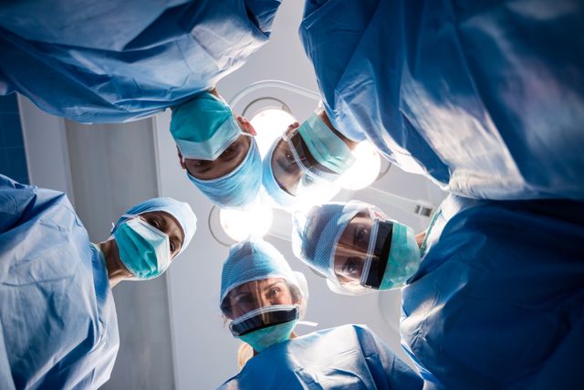 Group of surgeons looking at camera in operation room - Download Free Stock Photos Pikwizard.com