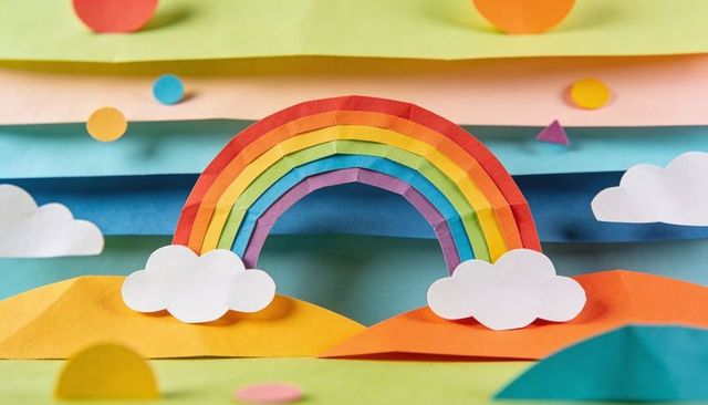 Colorful paper rainbow pop-up diorama with layered origami strips and clouds
