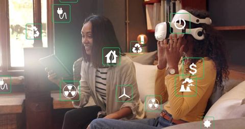 Two women using VR headset and tablet in sunlit living room with AR sustainability icons
