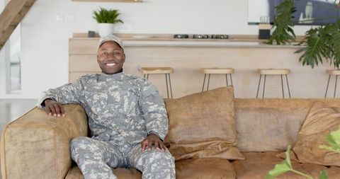 Happy soldier relaxing at home on comfortable couch