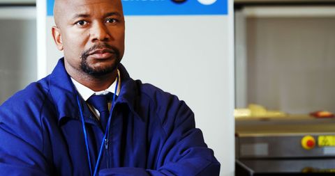 Security worker at airport standing with arms crossed